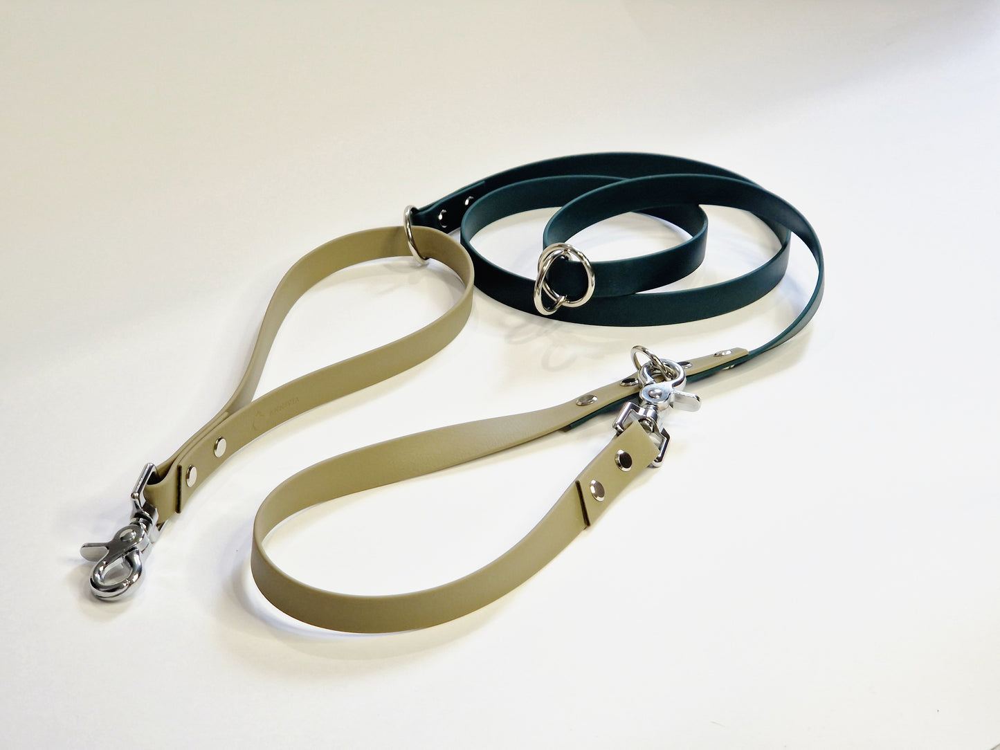 Powder Tan and Dark Green Biothane Multifunctional Dog Leash with Silver Carabiners, thoughtfully arranged for display.