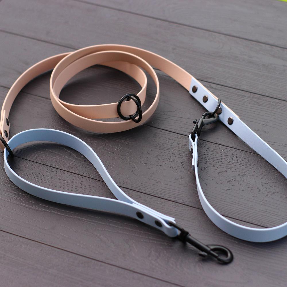 powder and Light Blue Biothane Multifunctional Dog Leash with Black Carabiners, gracefully arranged on a wooden surface.